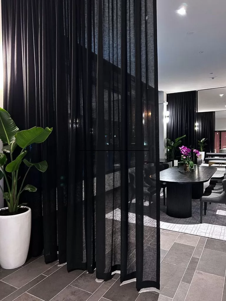 floor to ceiling black sheer curtains in a dining space