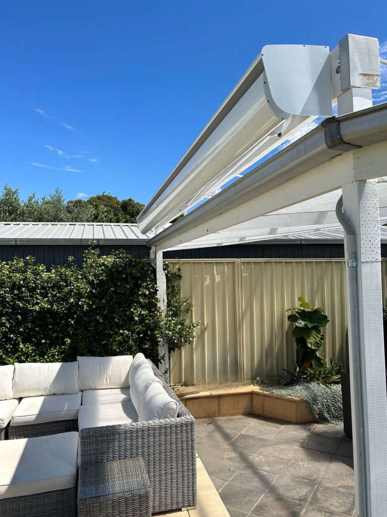 retractable awning fully retracted over outdoor entertaining area with white outdoor couch