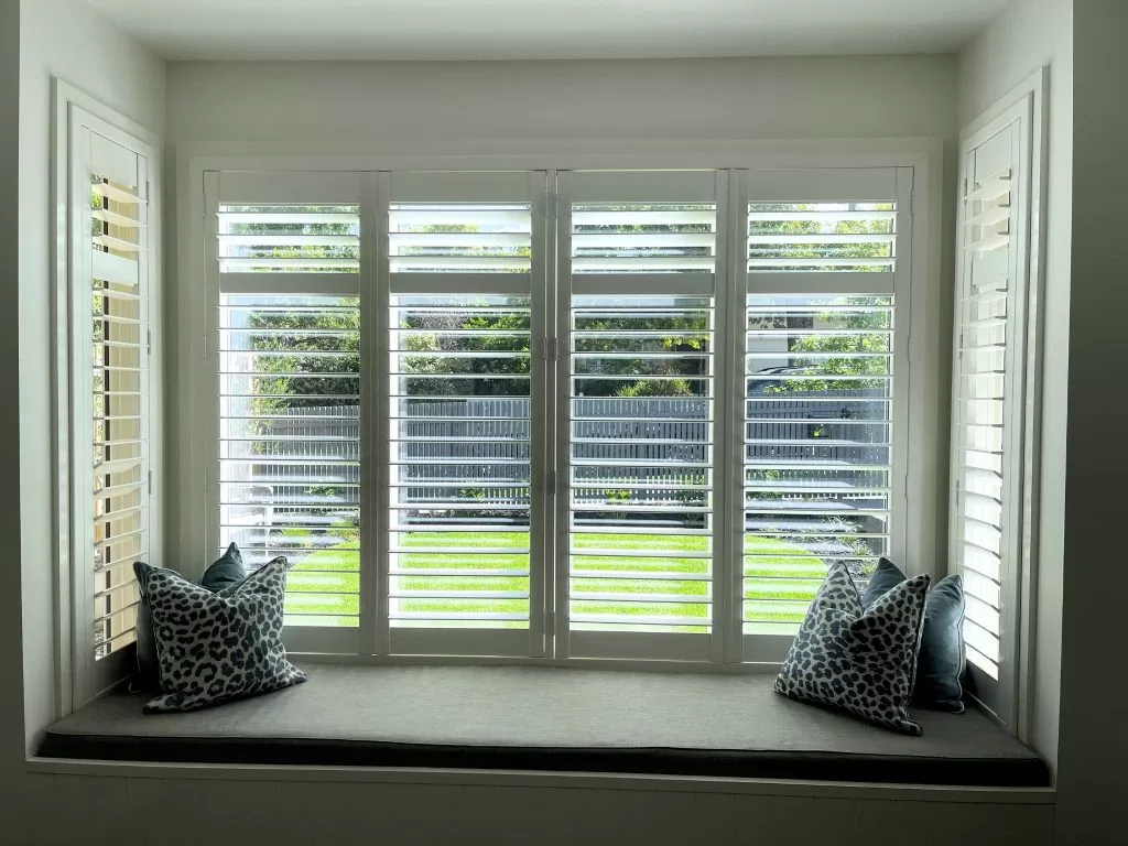 white plantation shutters on alcove looking out to front lawn